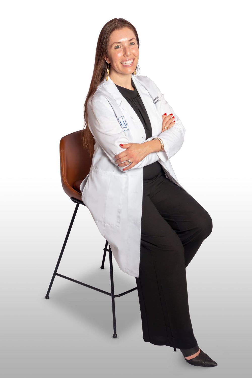 Board-certified dermatologist Dr. Cherise Levi in a white coat, seated and smiling